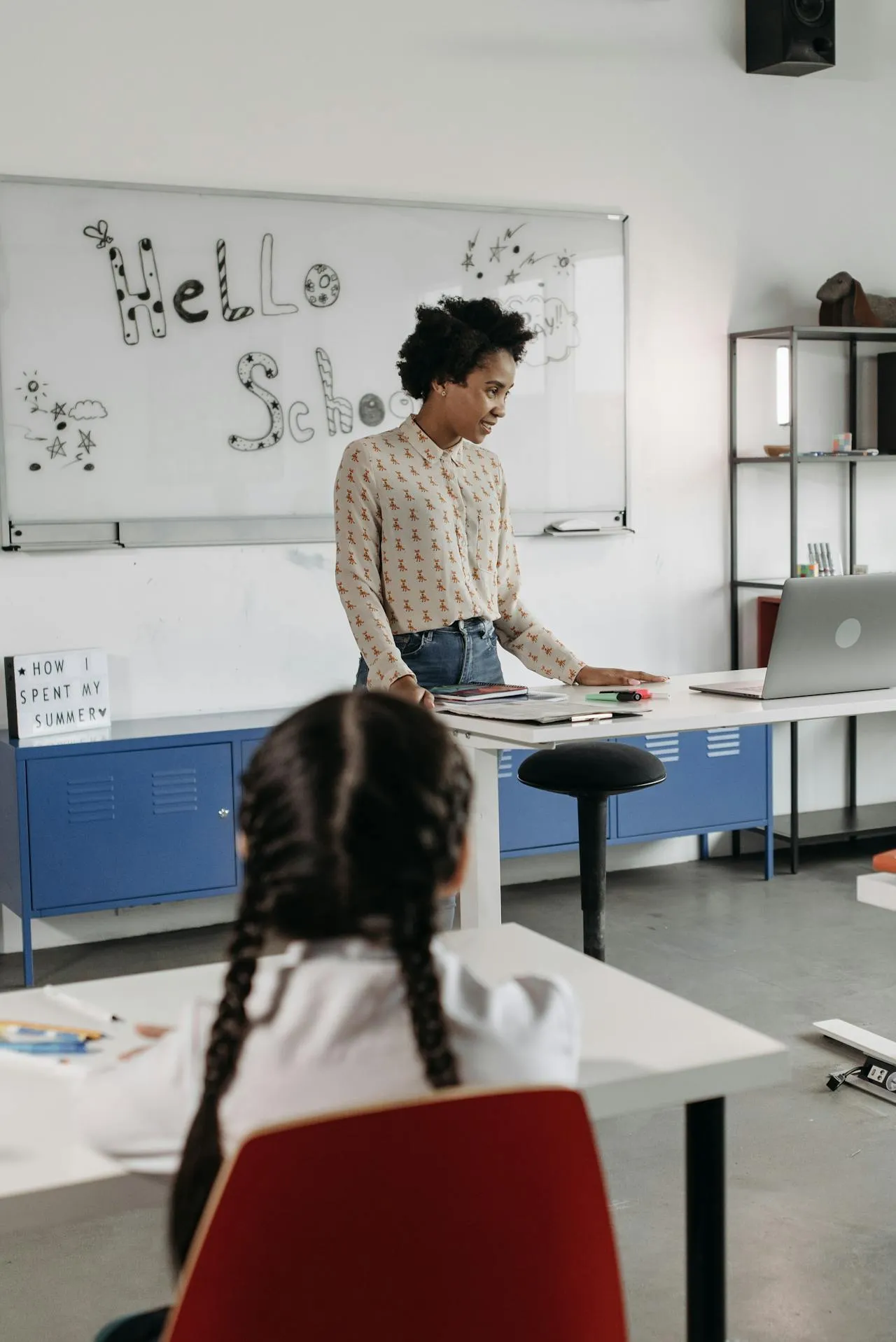 Teacher at desk working with technology in a classroom